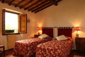 a bedroom with two beds and a window at Case Coloniche Berni in Impruneta