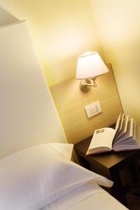a hotel room with a bed and a lamp at Regal Hotel in Brescia