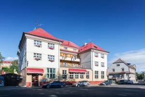 a large building with cars parked in front of it at Hotel Grand in Doksy