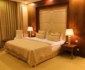- une chambre avec un grand lit et 2 lampes sur une table dans l'établissement Volga Premium Hotel, à Tcheboksary