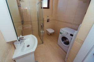 La salle de bains est pourvue d'un lavabo et d'un lave-linge. dans l'établissement Belvedere Apartments, à Petrovac na Moru