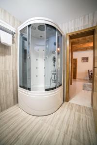y baño con ducha grande a ras de suelo con mampara de cristal. en Vila "Volujak" en Tjentište
