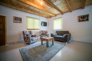 a living room with a couch and chairs and a table at Vila "Volujak" in Tjentište