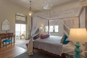 a bedroom with a canopy bed and a desk at Prana Home in Colombo