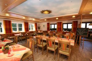 ein Restaurant mit Holztischen und -stühlen und einer Tafel in der Unterkunft Berghotel Sonnenklause in Sonthofen