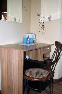 - un bureau en bois avec une chaise et une table avec des tasses dans l'établissement Affittacamere La Branda, à La Spezia