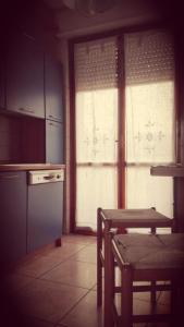 una cucina con tavolo, frigorifero e finestra di Casa Rosa a Porto SantʼElpidio