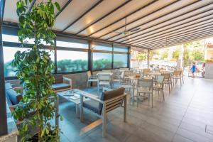 un ristorante con tavoli e sedie e una pianta di Hotel Originale by ALEhotels a Rimini