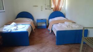 two beds in a room with blue headboards at Dakis Studios in Keri