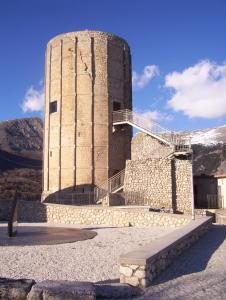 un edificio con una torre en la cima de una montaña en LITTLE TOWER en Aielli