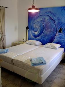een slaapkamer met een groot bed en een schilderij aan de muur bij Mike'sPlace in Antiparos Stad