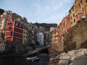 un groupe de bâtiments à côté d'une rivière avec des bateaux dans l'établissement Affittacamere La Branda, à La Spezia