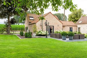 a house with a yard with green grass at Hof Leskensdaele Deluxe in Geraardsbergen