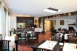 a dining room with tables and chairs in a restaurant at Isenburger Hof in Neu Isenburg