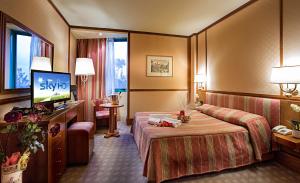 um quarto de hotel com uma cama e uma televisão de ecrã plano em Grand Hotel Duca D'Este em Tivoli Terme