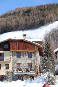 un edificio en la nieve frente a una montaña en CHALET de charme 13 personnes avec Sauna SKI O PIEDS en Saint-Martin-de-Belleville