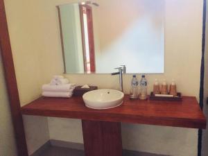 a bathroom counter with a sink and a mirror at The Tinsi in Nusa Penida