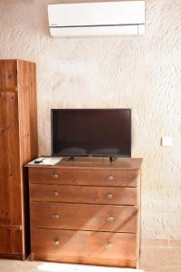 a dresser with a flat screen tv on top of it at Sirocave barlang apartmanok in Sirok