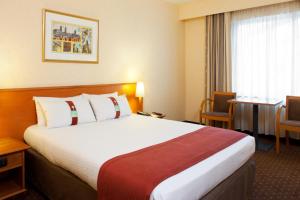 um quarto de hotel com uma cama grande e uma mesa em Holiday Inn Gent Expo, an IHG Hotel em Gent