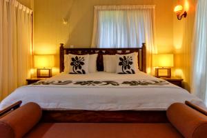 Te Ava Beach Villas في راروتونغا: غرفة نوم بسرير كبير فيها مصباحين