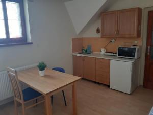 a small kitchen with a wooden table and a counter top at Penzion V Zatáčce in Pilsen