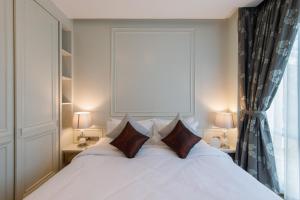 a bedroom with a white bed with pillows and a window at Parc Borough City Resort in Chiang Mai +101 photos