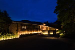 a house with lights on the side of it at night at barhotel Hakone Kazan in Hakone