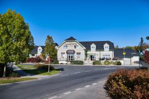 a large white house on a street with a driveway at Komorni Hurka in Cheb