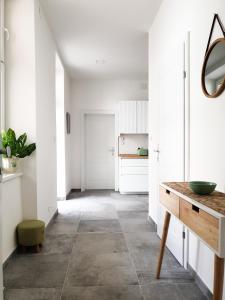 corridoio con pareti bianche, tavolo e specchio di cozy family apartment Ospelgasse a Vienna