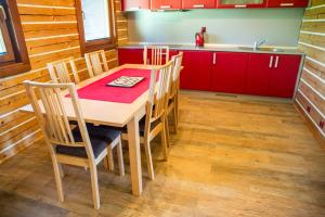 cocina con mesa de madera con sillas y fregadero en Lipno Island, en Frymburk