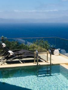 a swimming pool with a view of the ocean at Athina Epavlis - Ethereal Charm of Blue Horizons in Ravdhoúkha