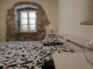 a bedroom with a bed with a stone wall at Apartment Mila Krk in Krk