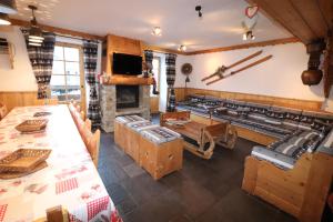 Habitación con mesas, sillas y chimenea. en CHALET de charme 13 personnes avec Sauna SKI O PIEDS en Saint-Martin-de-Belleville