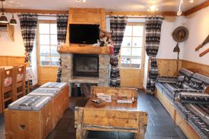 a living room with a fireplace and a tv at CHALET de charme 13 personnes avec Sauna SKI O PIEDS in Saint-Martin-de-Belleville