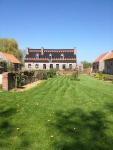 une grande cour avec une grande maison en arrière-plan dans l'établissement Paardenhof Guesthouse, à Esquelbecq