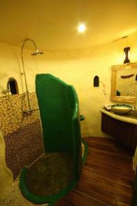 a bathroom with a green chair next to a sink at Mari Pai Resort in Pai