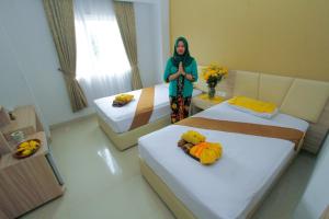 Ein Bett oder Betten in einem Zimmer der Unterkunft Lorin Syariah Solo Hotel