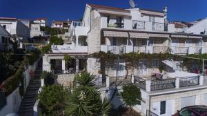 duży biały budynek z balkonami i drzewami w obiekcie Apartments Prosperina Hvar w Hvarze