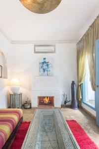 a living room with a fireplace and a couch at Riad Ayla avec Piscine Privée in Marrakesh