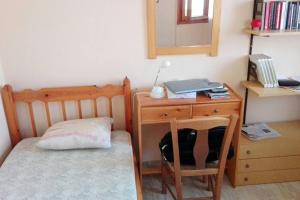 a bedroom with a desk and a bed and a chair at Sunny Beutiful Apartment in Lixouri