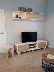 uma sala de estar com uma televisão de ecrã plano num centro de entretenimento em Apartamento Colón VUT-47-132 em Valladolid