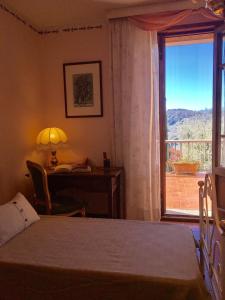 una camera da letto con scrivania, letto e finestra di Casa La Mignola a San Miniato