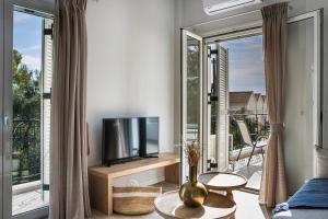 uma sala de estar com televisão e uma grande janela em Julia's Luxury Suites, Cephallonia near Argostoli em Kástron