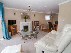 ein Wohnzimmer mit einer weißen Couch und einem Kamin in der Unterkunft The Duck House in Norwich