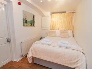 een slaapkamer met een bed met twee handdoeken erop bij Preswylfa Apartment in Caernarfon