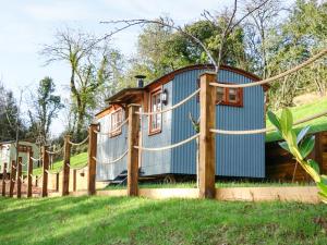 una casa en el árbol con una valla alrededor en Little Silver Fox, en High Bickington