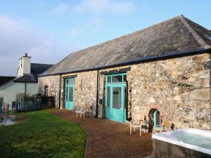 a stone house with blue doors and a patio at The Granary in Tavistock