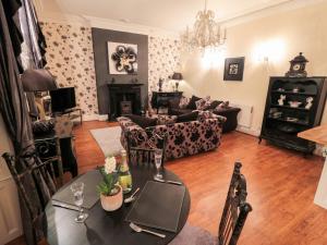 a living room with a table and a couch at Sneaton Hall Apartment 4 in Whitby