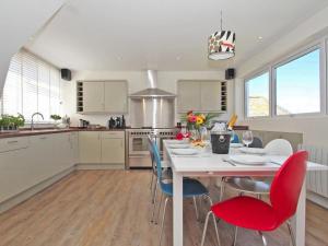 a kitchen with a white table and chairs in a kitchen at Seagrass in Newquay