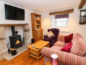 a living room with a couch and a fireplace at Linden Cottage in Smardale